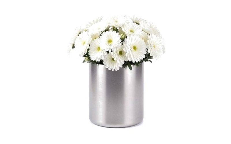 Florero cilíndrico ancho de acero con flores blancas